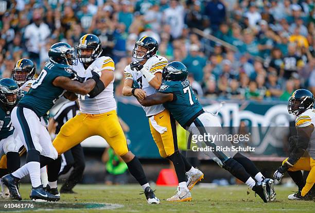 Quarterback Ben Roethlisberger of the Pittsburgh Steelers is hit by Vinny Curry of the Philadelphia Eagles just after throwing an incomplete pass in...