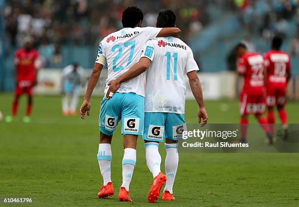 Carlos Lobaton of Sporting Cristal celebrates with teammate Diego Ifran after scoring the first goal of his team against Juan Aurich during a match...