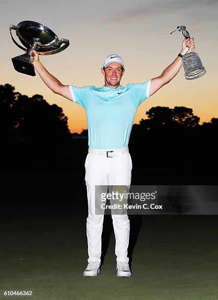 Rory McIlroy of Northern Ireland poses with the FedExCup and TOUR Championship trophies after his victory over Ryan Moore with a birdie on the fourth...