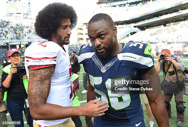 Quarterback Colin Kaepernick of the San Francisco 49ers speaks with defensive end Cliff Avril of the Seattle Seahawks after the game at CenturyLink...