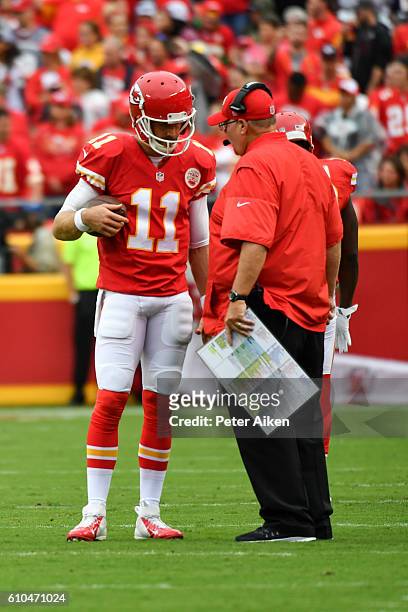 Quarterback Alex Smith of the Kansas City Chiefs talks with head coach Andy Reid during a time out against the New York Jets at Arrowhead Stadium...