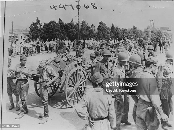 Japanese soldiers use handcarts to surrender their equipment to troops of the US Army's 7th Infantry Division in South Korea, September 1945.