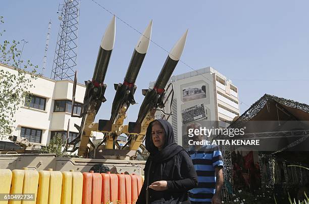 Iranians walk past Sam-6 missiles displayed in the street during a war exhibition to commemorate the 1980-88 Iran-Iraq war at Baharestan square,...