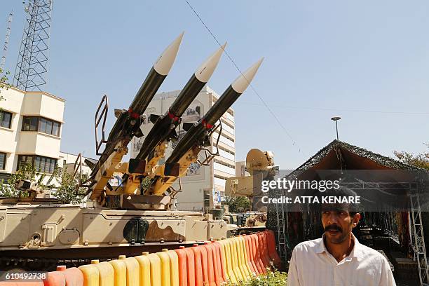 Iranian man walks past Sam-6 missiles displayed in the street during a war exhibition to commemorate the 1980-88 Iran-Iraq war at Baharestan square,...