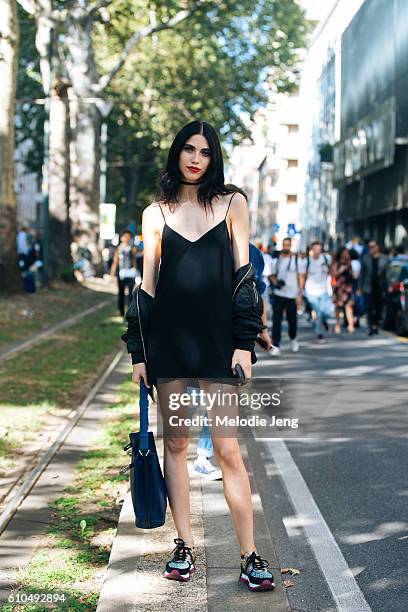 Model Diana Galimullina wears a black slip dress and Dolce & Gabbana sparkly sneakers during Milan Fashion Week Spring/Summer 2017 on September 25,...