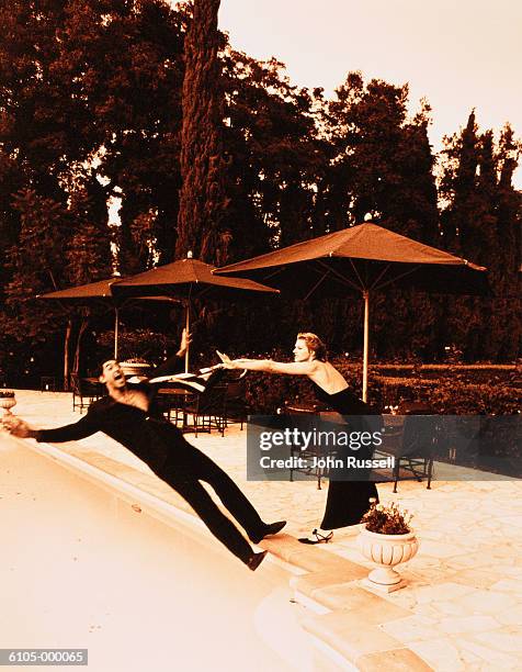 Woman Pushing Man Into Swimming Pool Photos and Premium High Res ...
