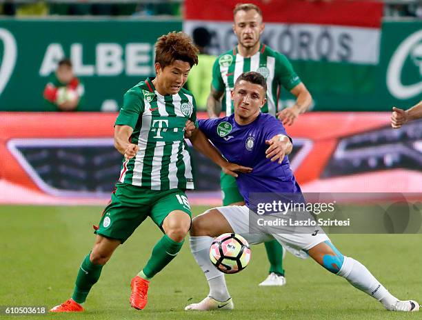 Seung-Woo Ryu of Ferencvarosi TC duels for the ball with Enis Bardhi of Ujpest FC before Gergo Lovrencsics of Ferencvarosi TC during the Hungarian...