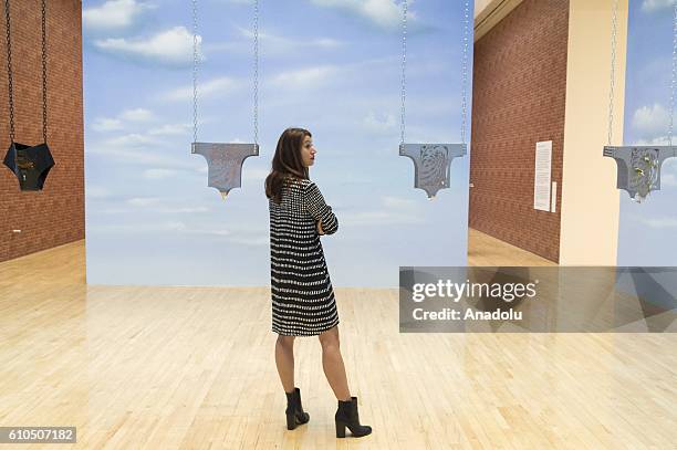 Member of staff poses next to an installation entitled 'Guimard Chastity Belt' during a press preview for the 2016 Turner Prize at Tate Britain in...