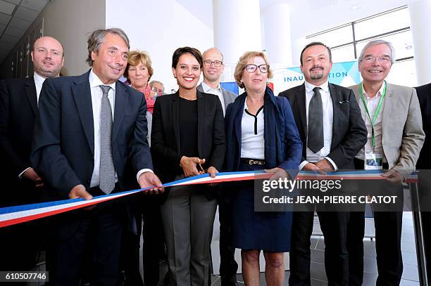 French Education minister Najat Vallaud-Belkacem , next to members of parliament Genevieve Fioraso and Michel Destot , is about to cut a ribbon to...