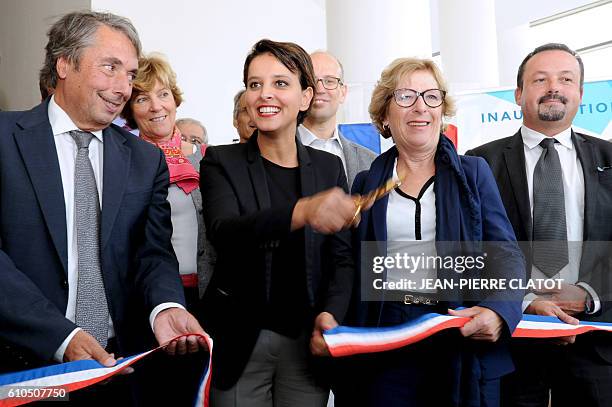 French Education minister Najat Vallaud-Belkacem , next to members of parliament Genevieve Fioraso and Michel Destot , cuts a ribbon to inaugurate a...