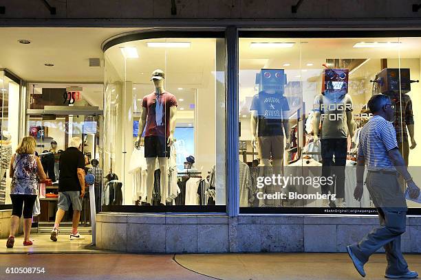 Shoppers enter an Original Penguin clothing store, operated by Perry Ellis International Inc., at the Lincoln Road Mall in Miami Beach, Florida,...