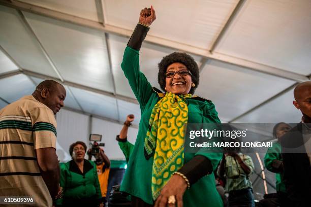 Africa National Congress stalwart Winnie Madikizela Mandela raises her fist in her signature move as she acknowledges a crowd of ANC Women League...