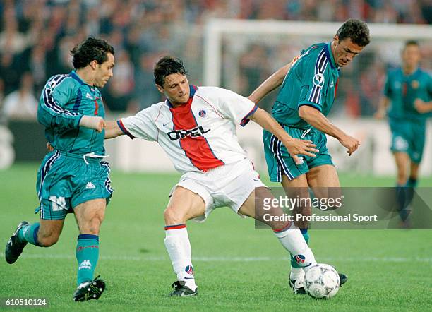 Laurent Fournier of Paris Saint-Germain is challenged by Barcelona defenders Sergi Barjuan and Gheorghe Popescu during the UEFA European Cup Winner's...
