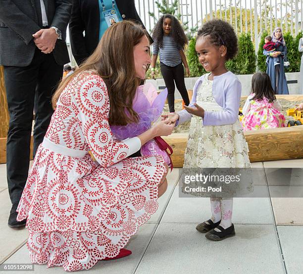 Catherine, Duchess of Cambridge meets a young girl as she visits the Immigrant Services Society's new Welcome House on September 25, 2016 in...