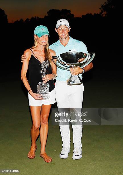Rory McIlroy of Northern Ireland poses alongside his girlfriend Erica Stoll and the FedExCup and TOUR Championship trophies after his victory over...