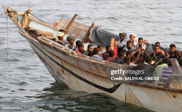 African illegal immigrants sit on a boat in the southern port city of Aden on September 26 before being deported to Somalia. Yemeni authorities...