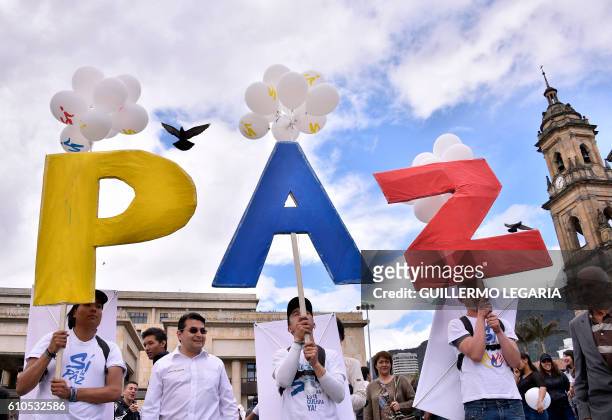 People gather at Bogota's Bolivar main square on September 26 to celebrate the historic peace agreement between the Colombian government and the...