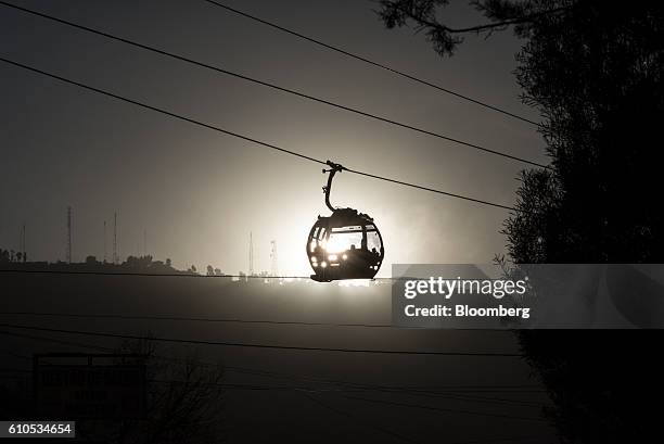 Travelers ride on the green line Mi Teleferico cable car above the city of La Paz, Bolivia, on Wednesday, Sept. 14, 2016. Boliva's Mi Teleferico...