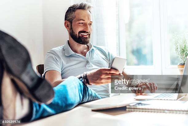 glücklicher bärtiger mann macht geschäft im web zu hause - geschäftsmann im büro mobiltelefon stock-fotos und bilder