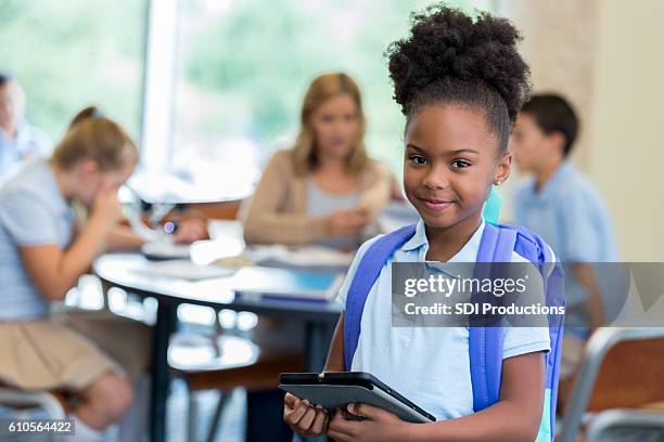 confident  elementary schoolgirl in classroom - charter school stock pictures, royalty-free photos & images