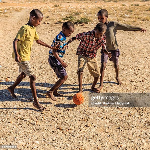 barefoot african children playing football in the village, east africa - kenyansk kultur bildbanksfoton och bilder