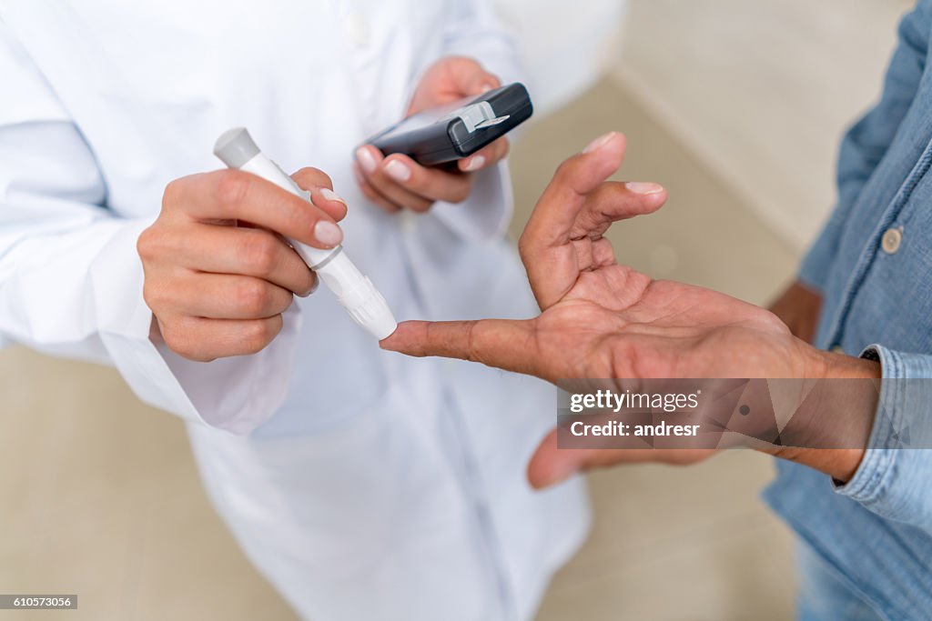 Homem verificando nível de açúcar com glucometer