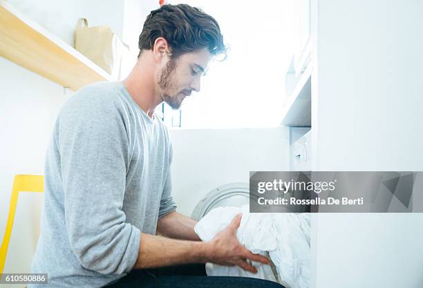l'uomo a casa che fa il bucato - white laundry foto e immagini stock
