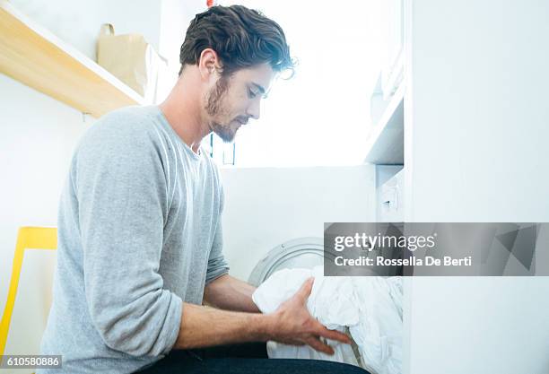 man at home doing laundry - washing machine imagens e fotografias de stock