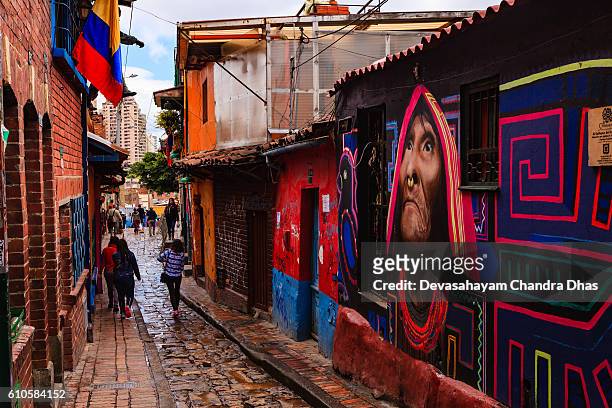 bogoté, kolumbien - menschen gehen durch die enge, bunte, gepflasterte calle del embudo im historischen stadtteil la candelaria - la candelaria bogota stock-fotos und bilder