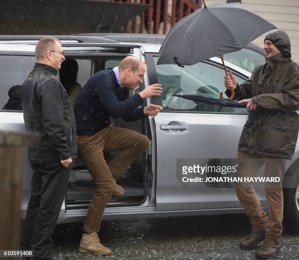 Prince William the Duke of Cambridge gets out of his car under heavy rain as he arrive in Bella Bella, British Columbia on September 26, 2016.