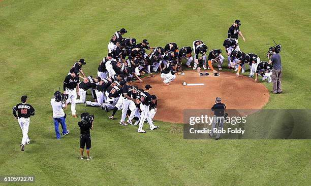 Miami Marlins players all wearing jerseys bearing the number 16 and name Fernandez honor the late Jose Fernandez before the game against the New York...