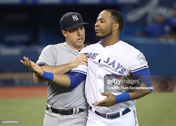 Edwin Encarnacion of the Toronto Blue Jays is restrained by Mark Teixeira of New York Yankees during a bench-clearing incident in the second inning...