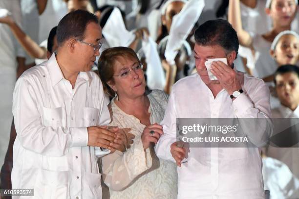 Secretary general Ban Ki-moon and Chilean President Michelle Bachelet look at Colombian President Juan Manuel Santos at the end of the signing...