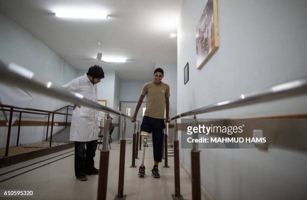 Doctor supervises as Mohannad Aid , a 20-year-old Palestinian who lost his leg when he was hit by a rocket during the 50-day war between Israel and...