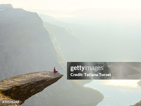 Woman sitting on the edge of a cliff Woman sitting on the edge of a cliff