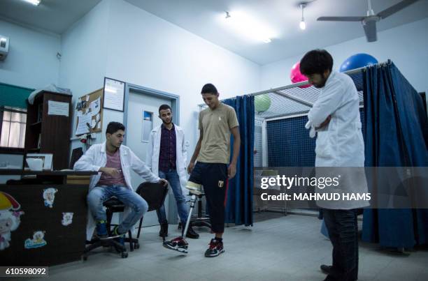 Doctors supervise as Mohannad Aid , a 20-year-old Palestinian who lost his leg when he was hit by a rocket during the 50-day war between Israel and...