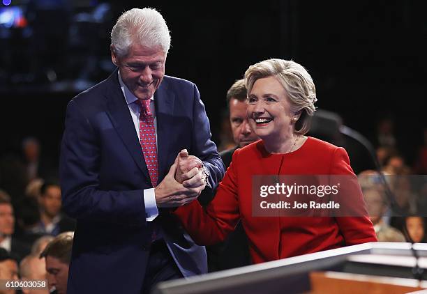 Democratic presidential nominee Hillary Clinton shakes hands with husband and former U.S. President Bill Clinton after the Presidential Debate with...