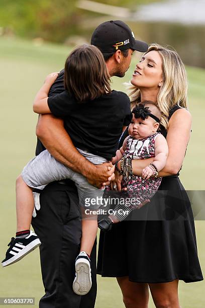 Jason Day of Australia kisses his wife Ellie with their kids Dash and Lucy after his victory on the 18th hole green during the final round of the...