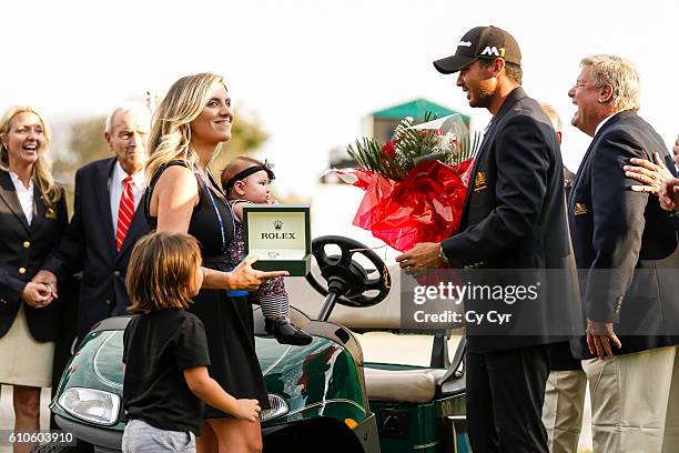 Jason Day of Australia is presented with a Rolex watch as his wife Ellie and their kids Lucy and Dash look on during a trophy ceremony following...