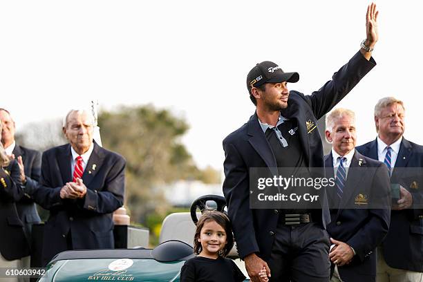 Jason Day of Australia, with his son Dash, waves to fans during a trophy ceremony following his one stroke victory on the 18th hole green in the...