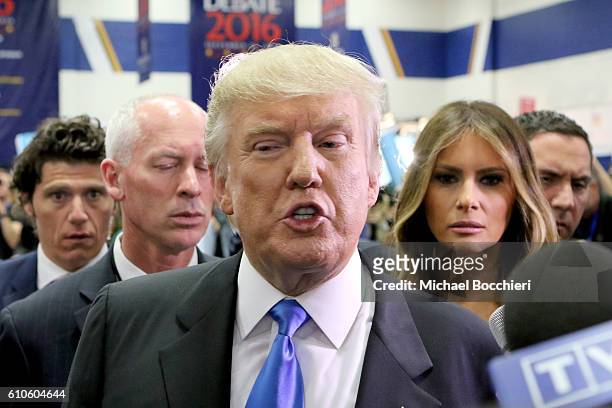 Republican presidential nominee Donald Trump speaks to the media in the spin room as wife, Melania Trump looks on during the Presidential Debate at...