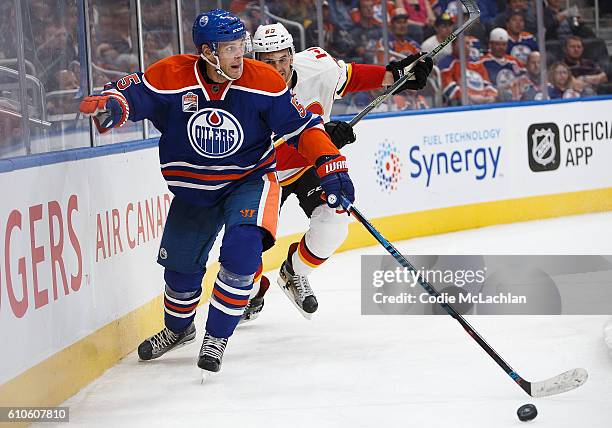 Mark Fayne of the Edmonton Oilers defends his zone against Jamie Devane of the Calgary Flames in an NHL preseason game on September 26, 2016 at...