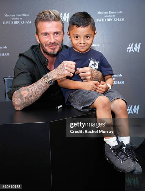 David Beckham poses for photos with fans during the launch of David Beckham's H&M Modern Essentials Collection on September 26, 2016 in H&M at...