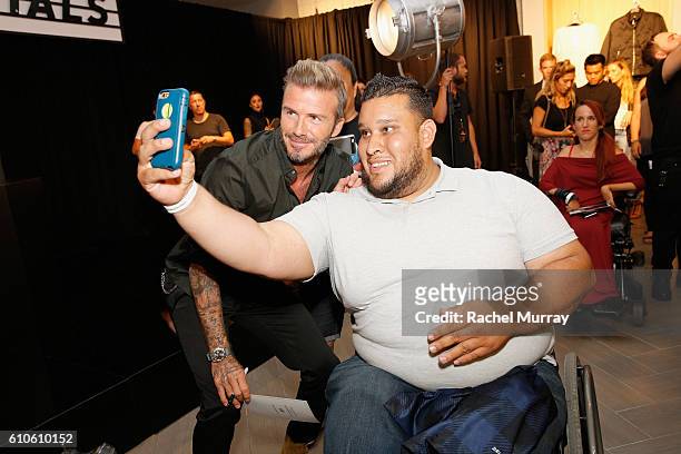 David Beckham poses for photos with fans during the launch of David Beckham's H&M Modern Essentials Collection on September 26, 2016 in H&M at...