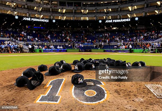 Miami Marlins leave their hats on the pitching mound to honor the late Jose Fernandez after the game against the New York Mets at Marlins Park on...