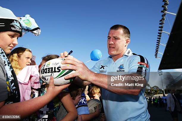 Paul Gallen of the Sharks signs autographs for fans during a Cronulla Sharks NRL training session at Southern Cross Group Stadium on September 27,...