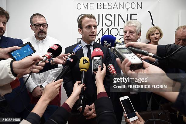 Former French Economy Minister and founder of the political movement "En Marche" Emmanuel Macron , flanked by Besancon mayor Jean-Louis Fousseret...