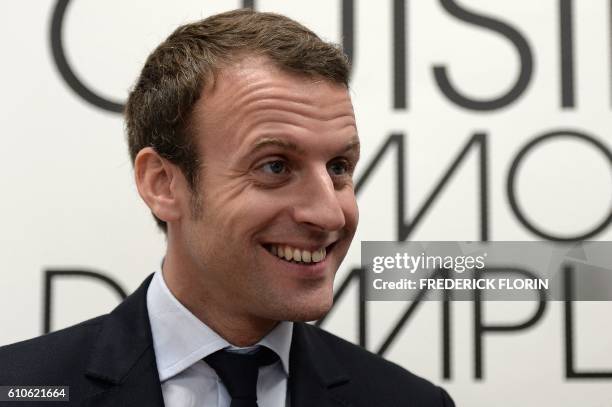 Former French Economy Minister and founder of the political movement "En Marche" Emmanuel Macron smiles during a visit at the cooking school "Cuisine...