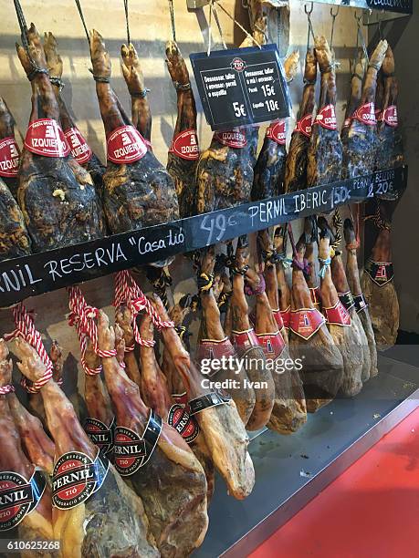 hams (jamon de serrano) in la boqueria market barcelona - jamon serrano photos et images de collection