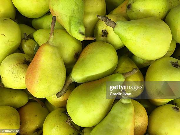 full frame shot of organic raw green pears in market - kelly green stock-fotos und bilder